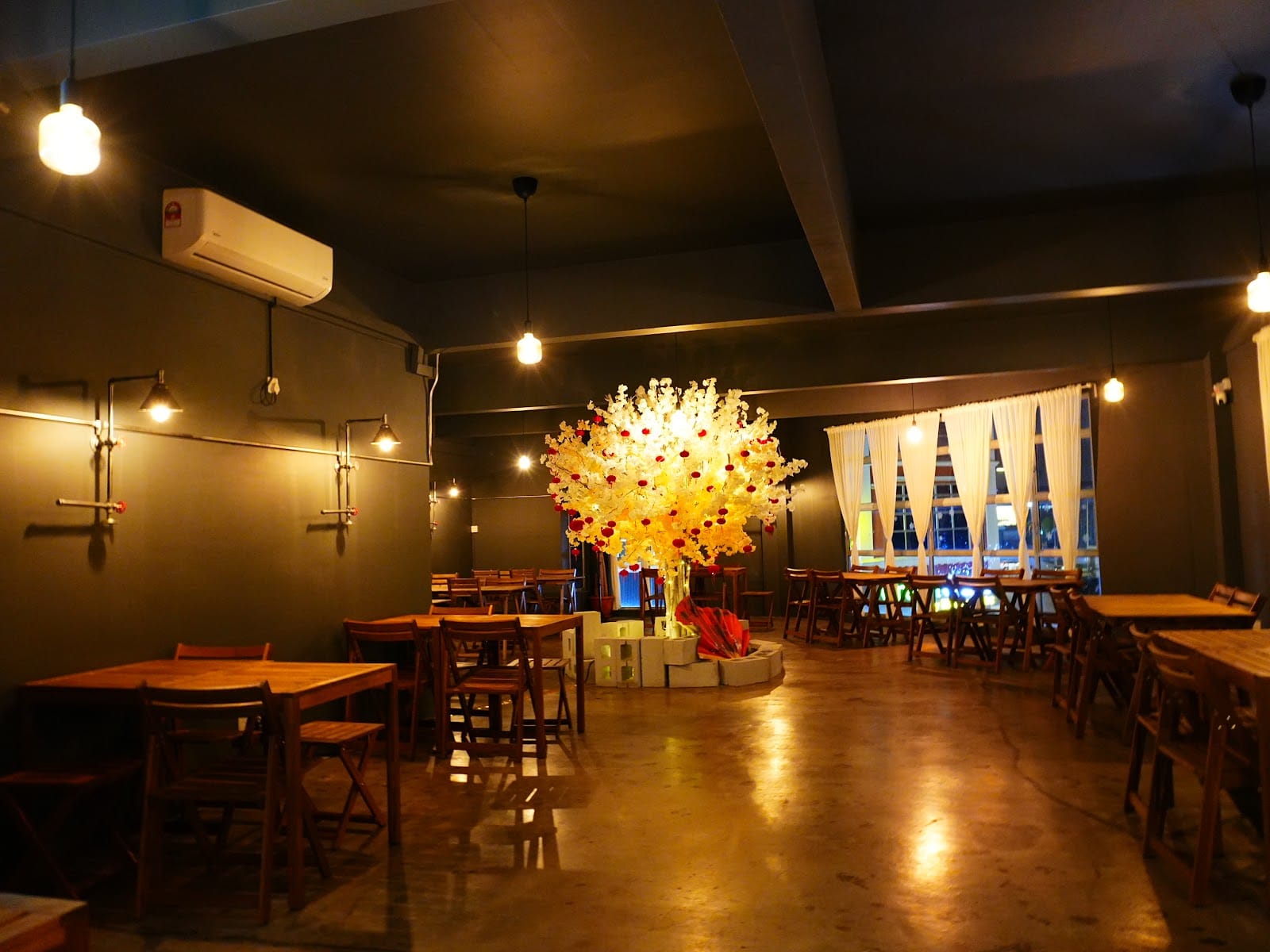 The Blue Door Coffee House dining room after dark, lit by paper lanterns and a lit-up flower centrepiece