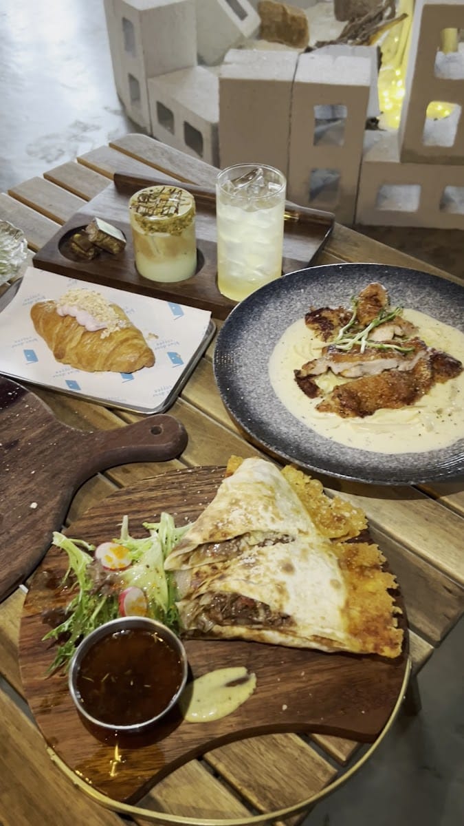 A table spread of croissants, drinks and a chicken dish at The Blue Door Coffee House